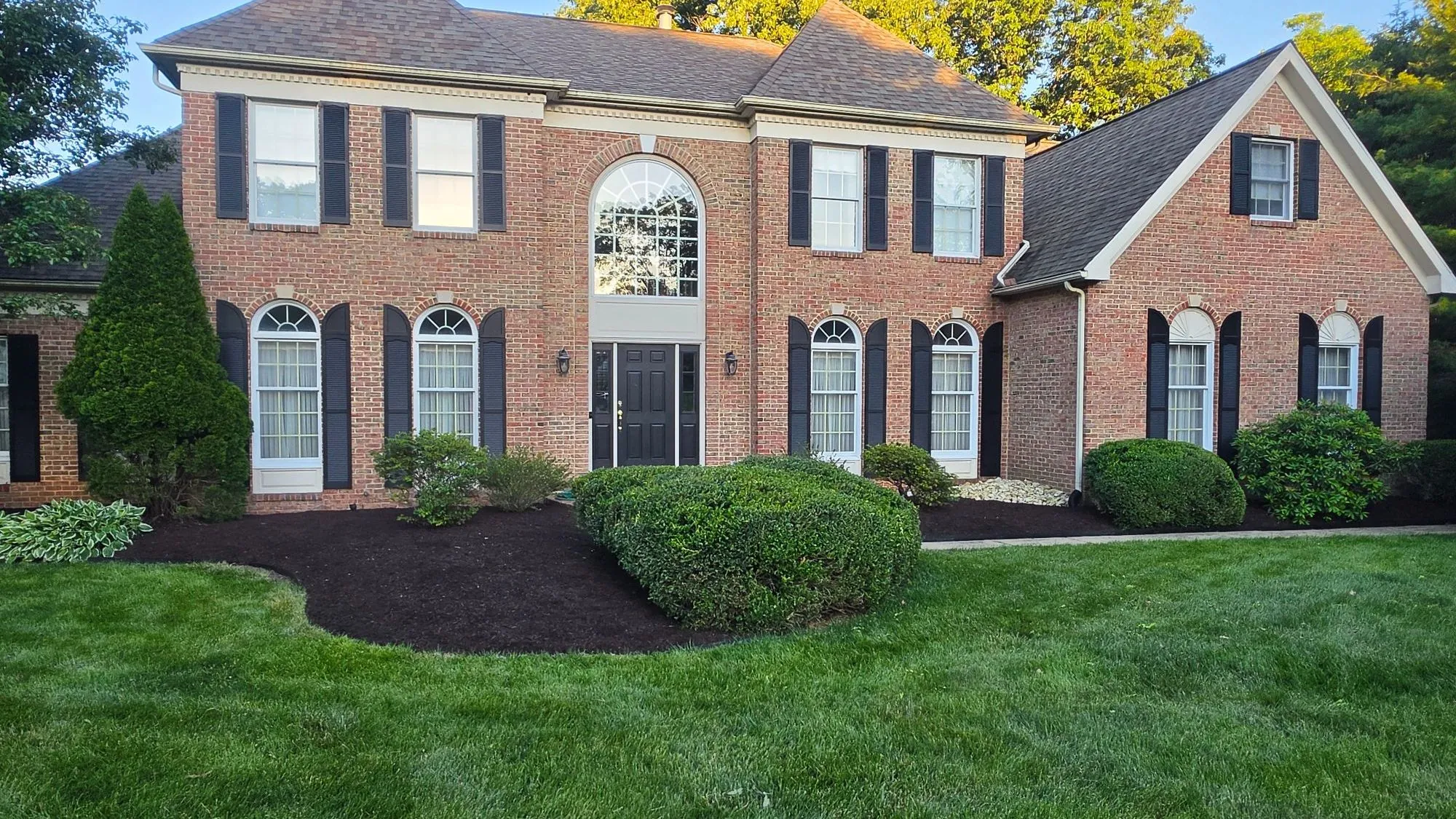 Brick home with a freshly mown lawn and mulched landscape beds